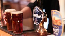 Image of pints of beer being served at a bar