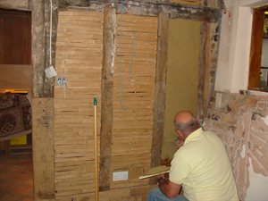 repairs being carried out to an interior wall of a listed building
