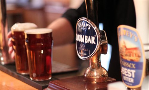 Pints of beer being served at a bar