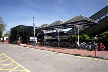 The exterior of Radlett station with a row of parked bicycles.