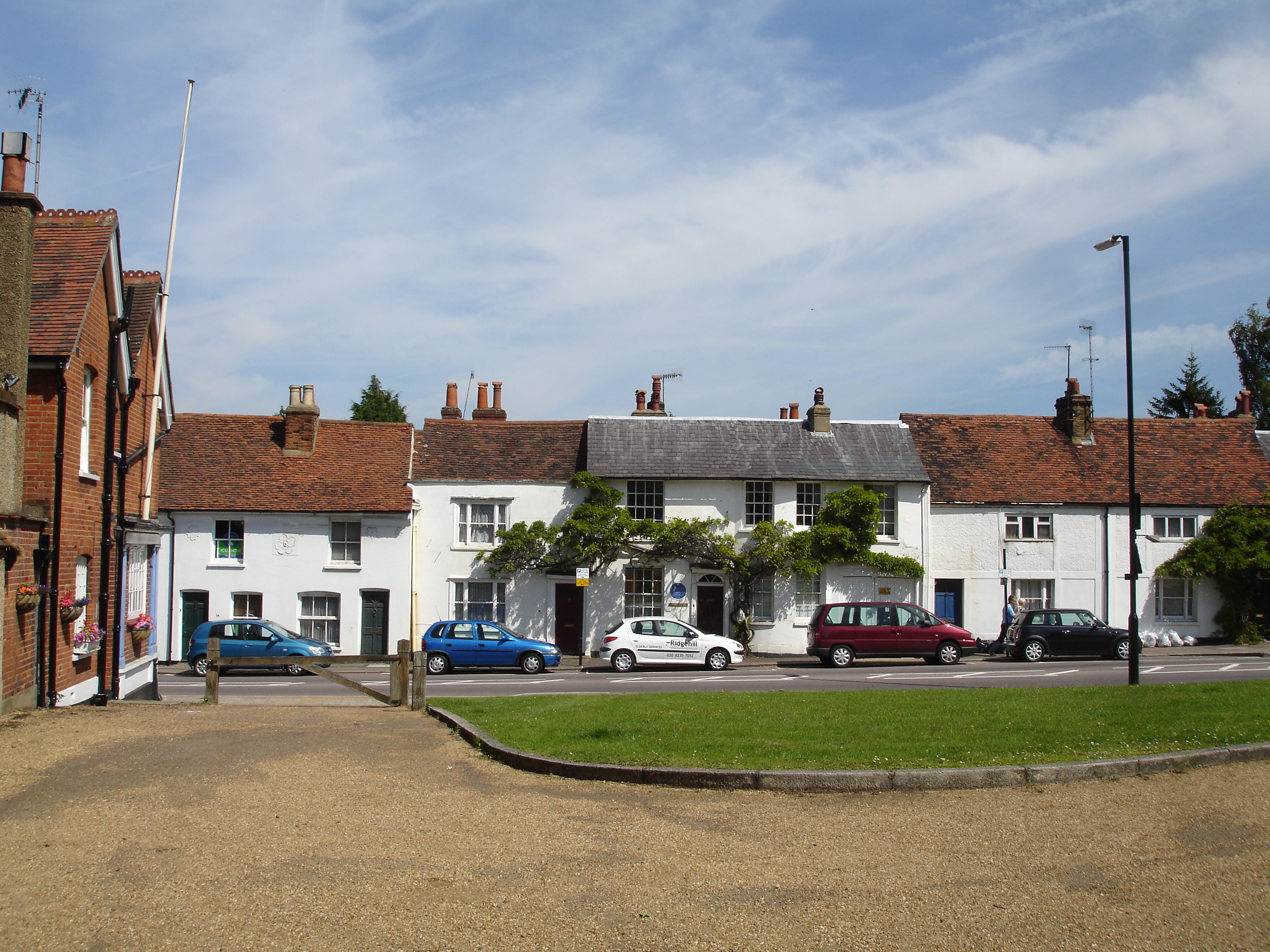 High street in Bushey with a row of houses and cars