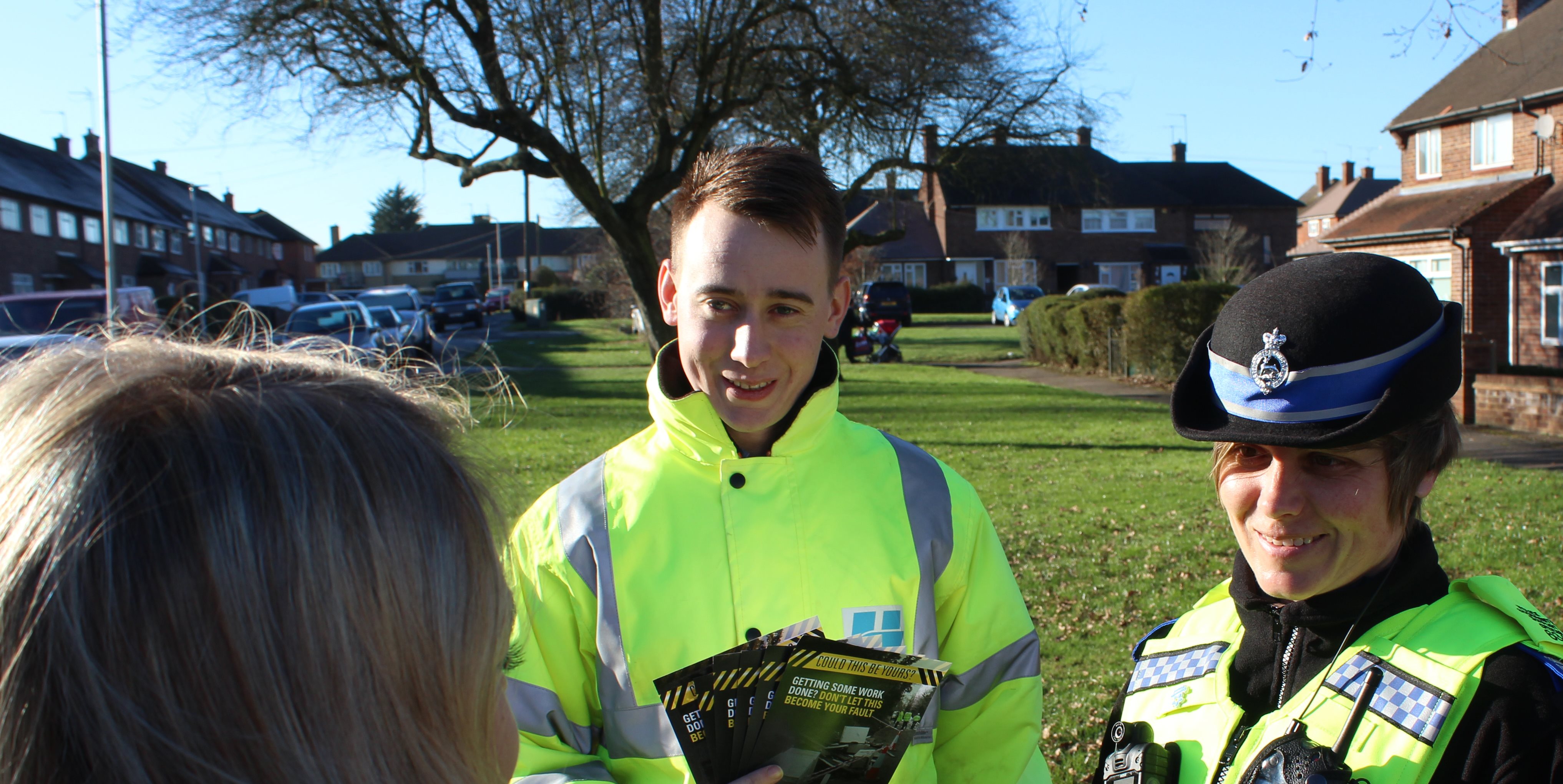 Two police officers handing out flytipping leaflets to the public.