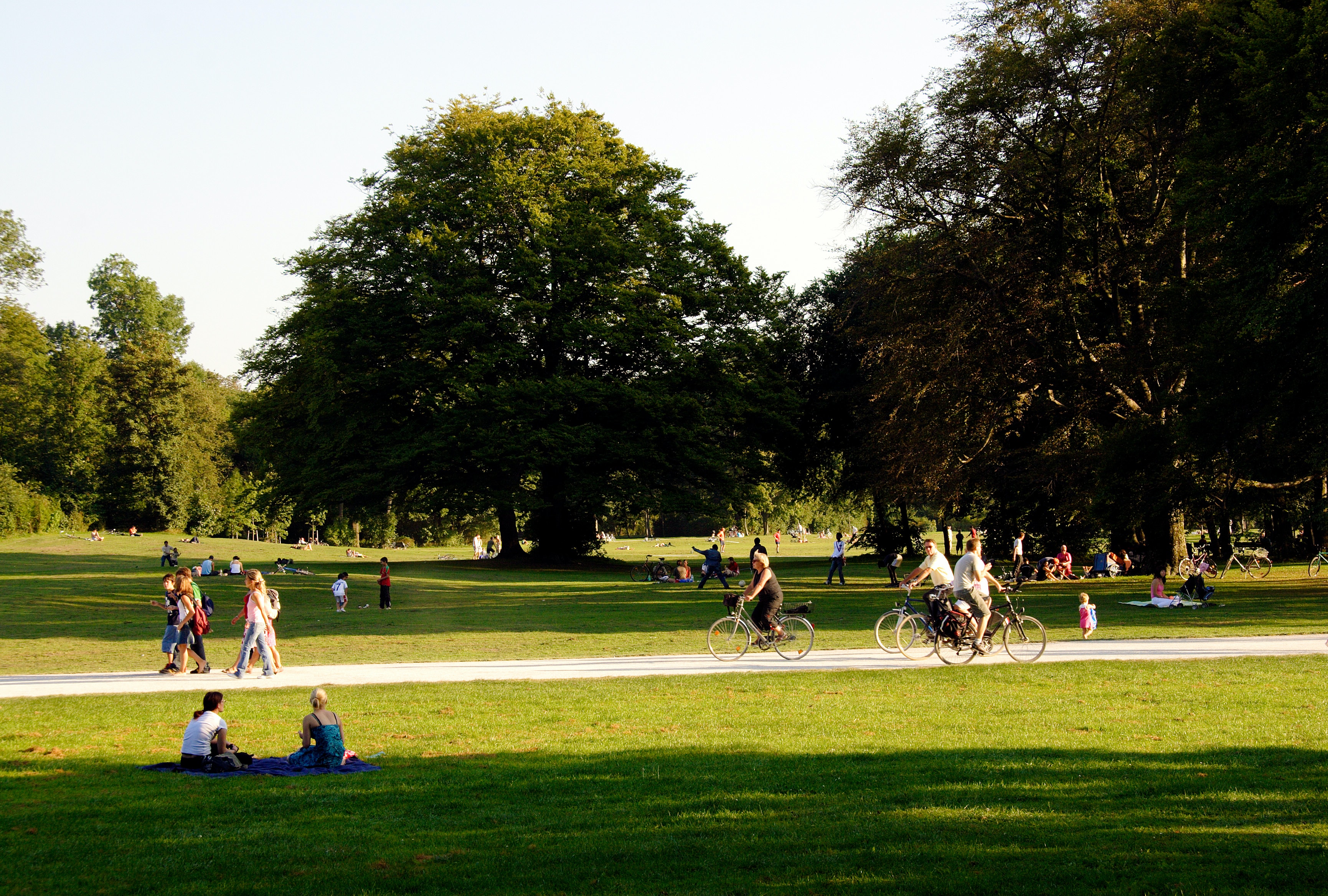 People running, walking and riding bikes in an open park space