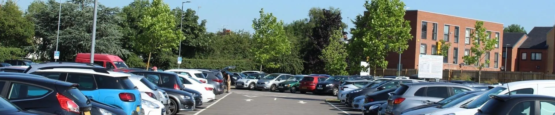 A car park with cars parked in each bay.