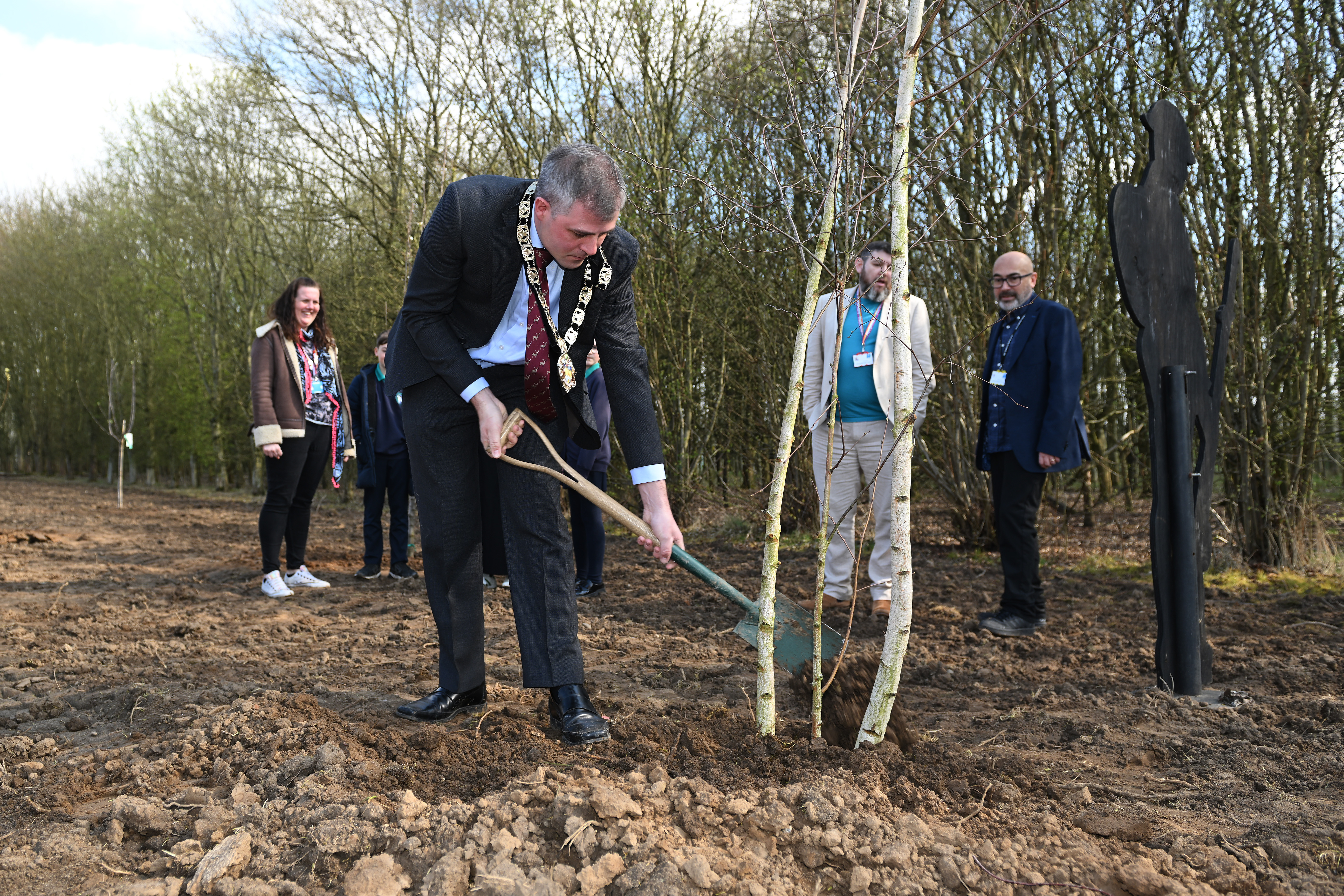 Cllr Richard Butler plants a tree during the event.