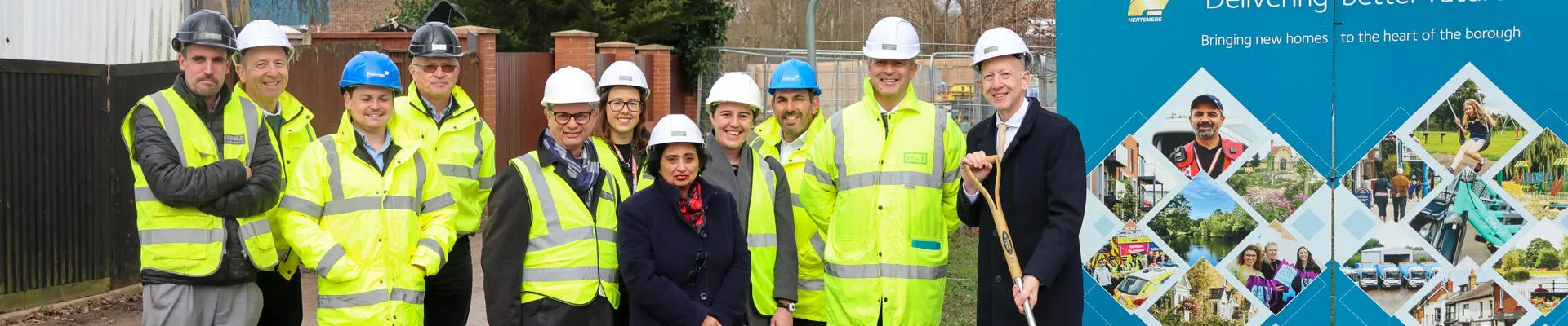 Group in high visibility vests assembled outside building site.