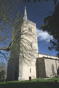 Exterior of Aldenham church with trees hanging over the building.